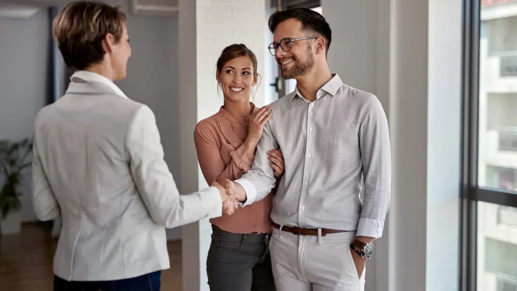 Picture of two patients living a full life, shaking hands with a realtor.